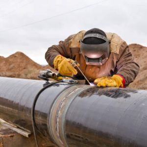 Homepage Welder working on an outdoor pipeline